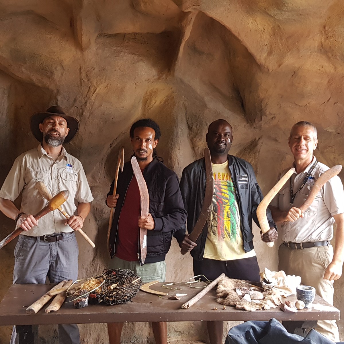 a couple of people that are standing in front of a rock