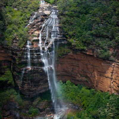 a large waterfall in a forest with Devon Falls in the background